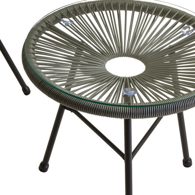 Round glass table with wicker-like top and metal legs on a white background