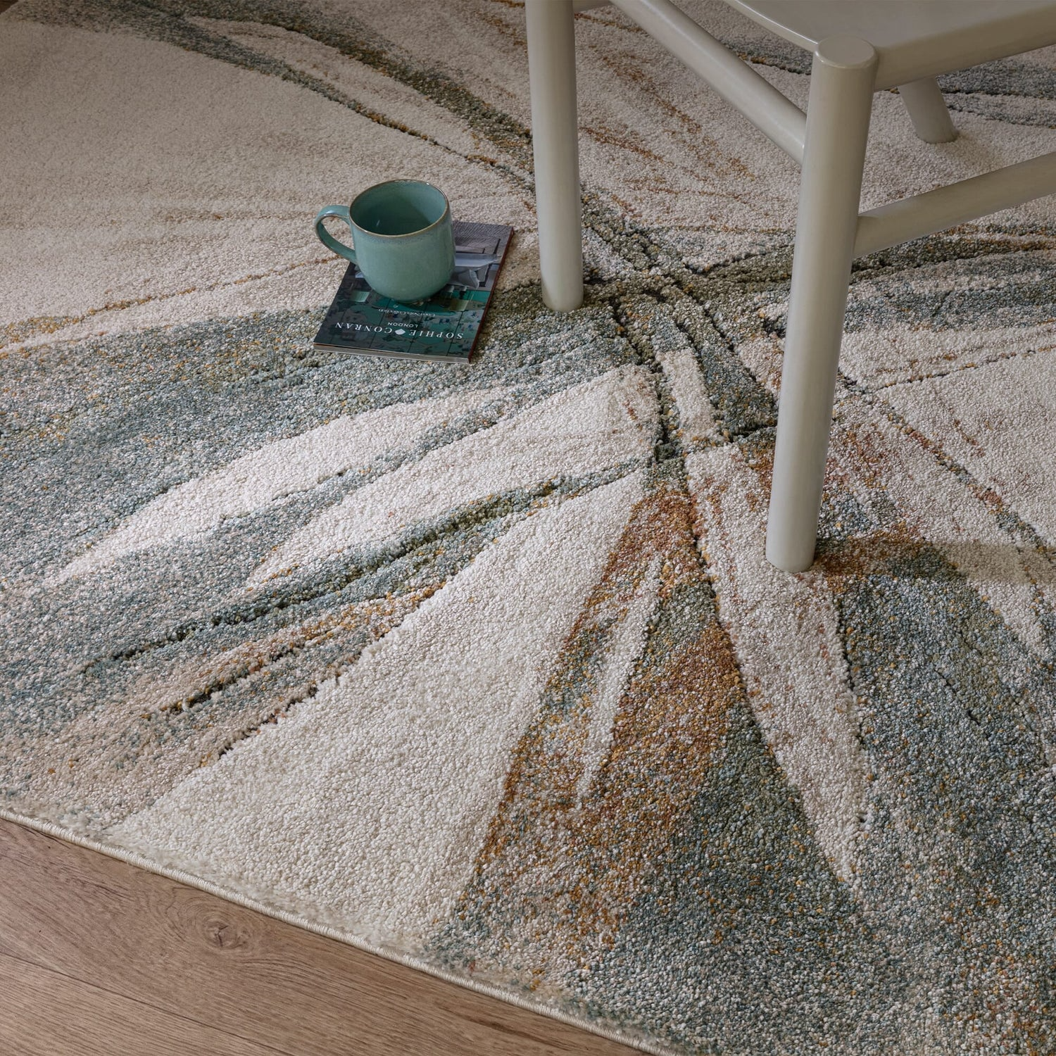 Patterned rug with a chair and a cup on a wooden floor