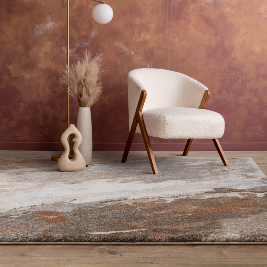 Modern armchair with wooden legs in a room with a textured wall and decorative rug.