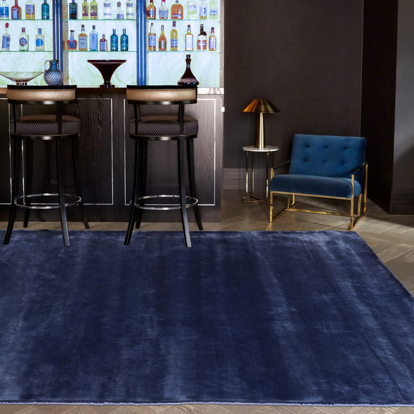 Navy blue rug in a modern bar setting with bar stools and a chair.