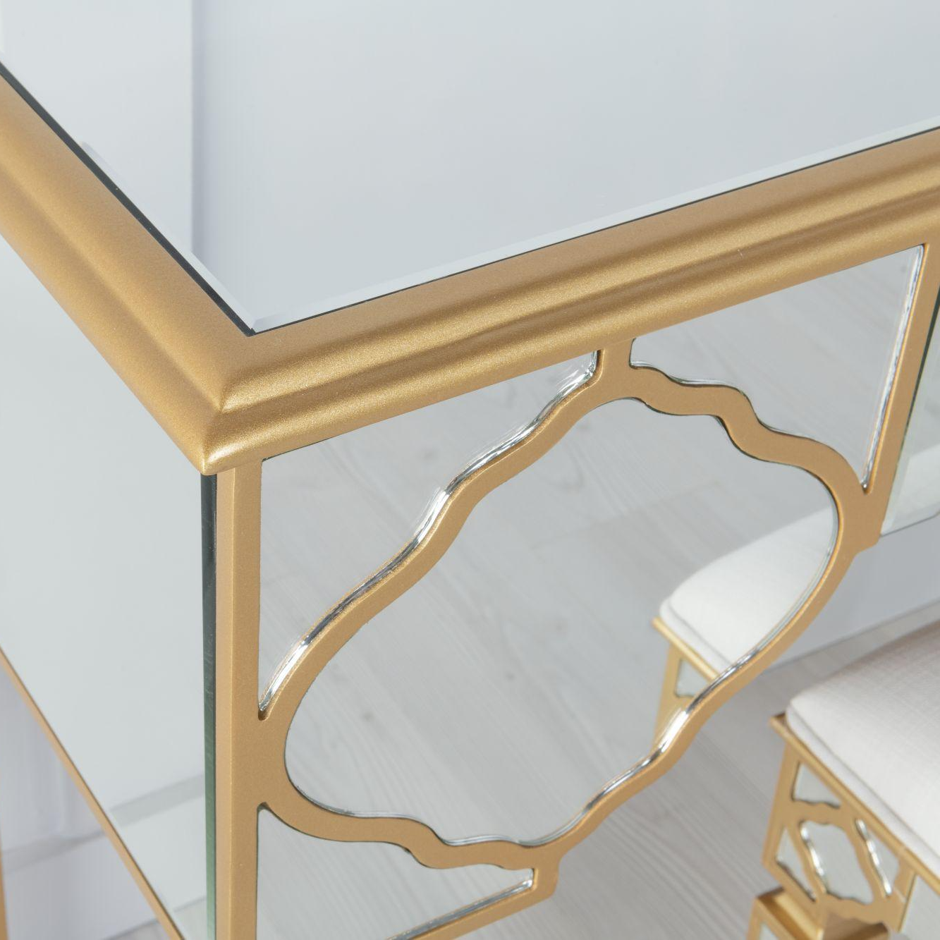 Gold-framed dresser with intricate design on a white background