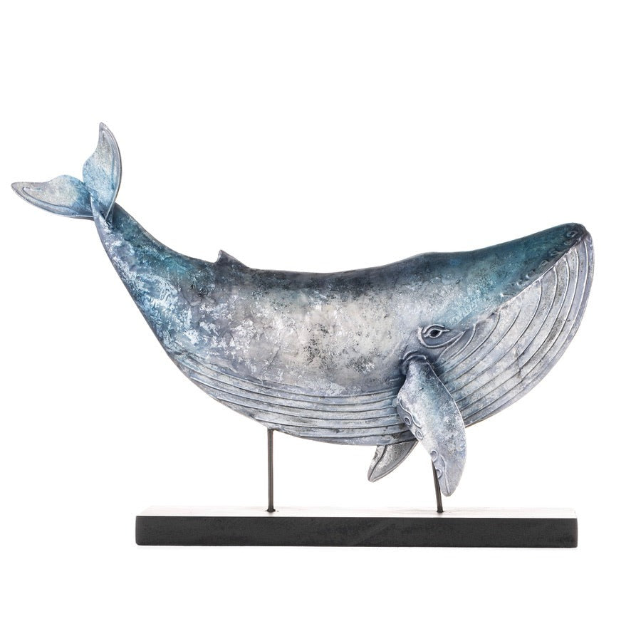 Iridescent blue whale sculpture on a black stand, featuring a metallic finish and textured detailing, ideal for nautical or coastal home decor.