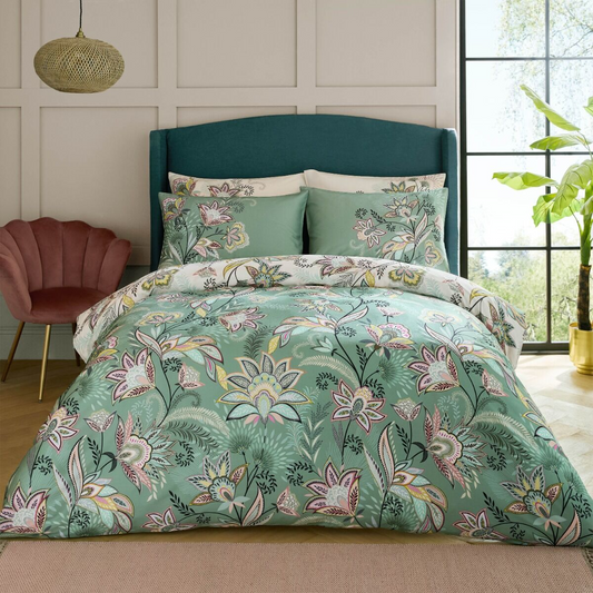 Floral bedding set on a bed with a teal headboard in a room with a window and plant.