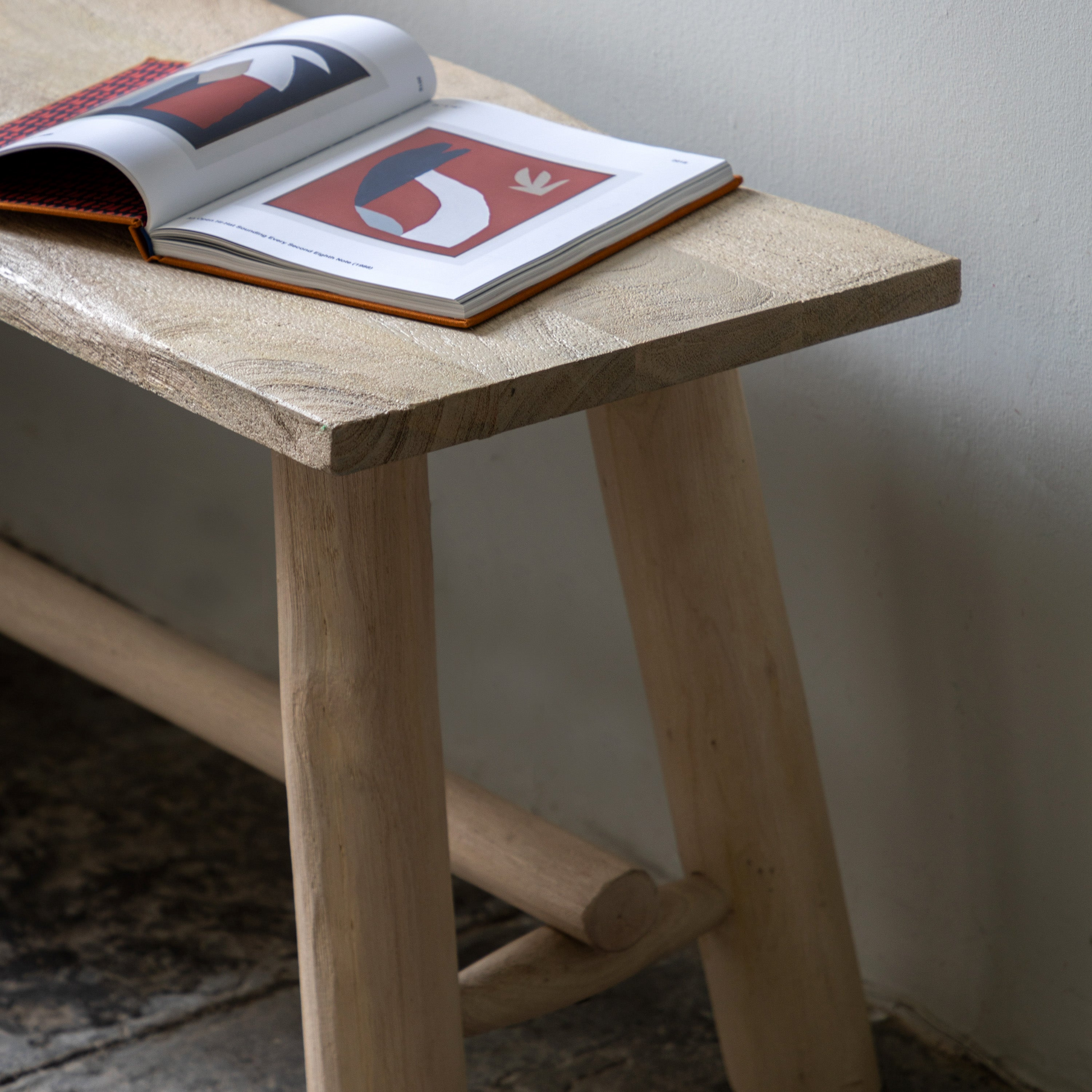 Wooden bench with an open book on a plain background