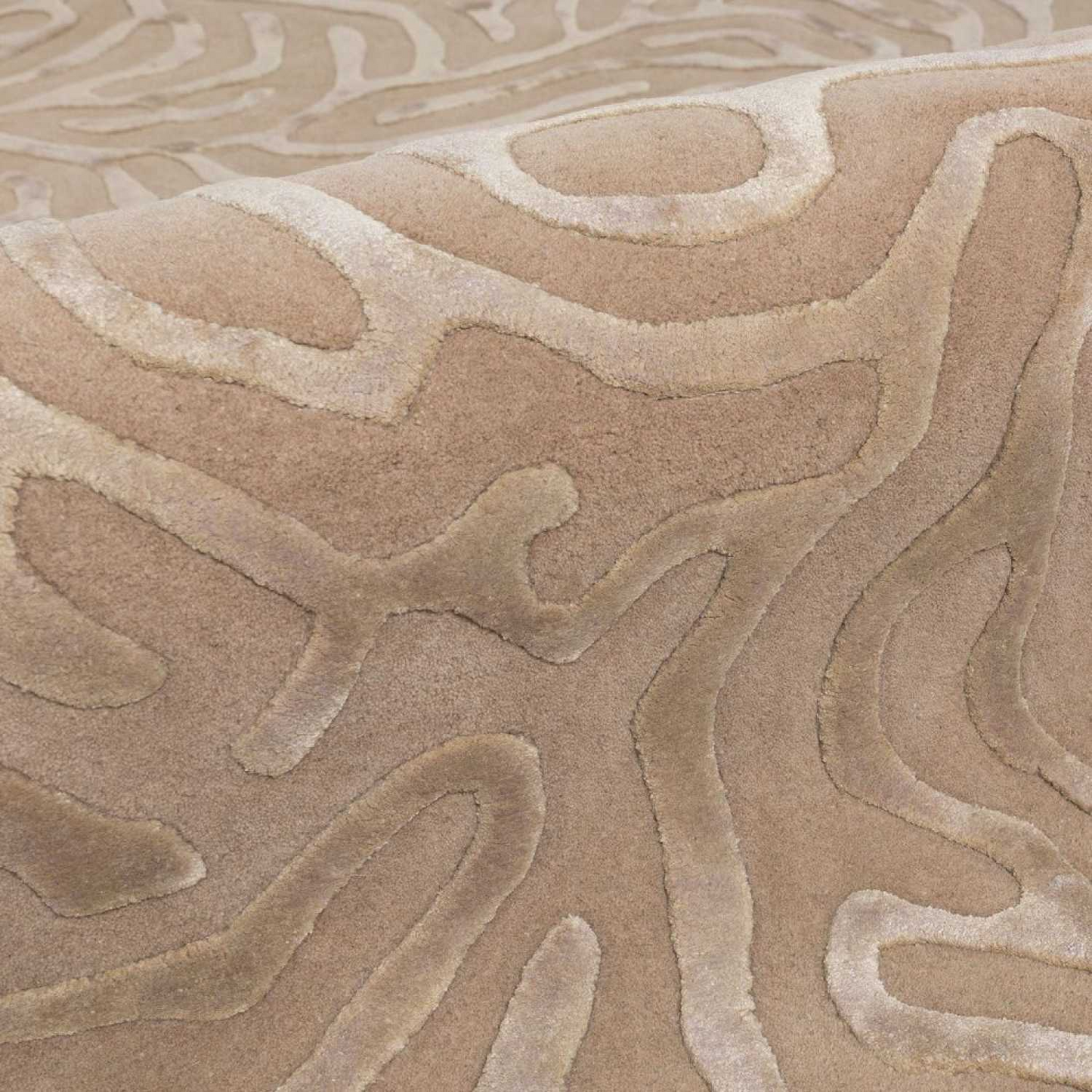 Close-up of a textured beige carpet with wavy pattern
