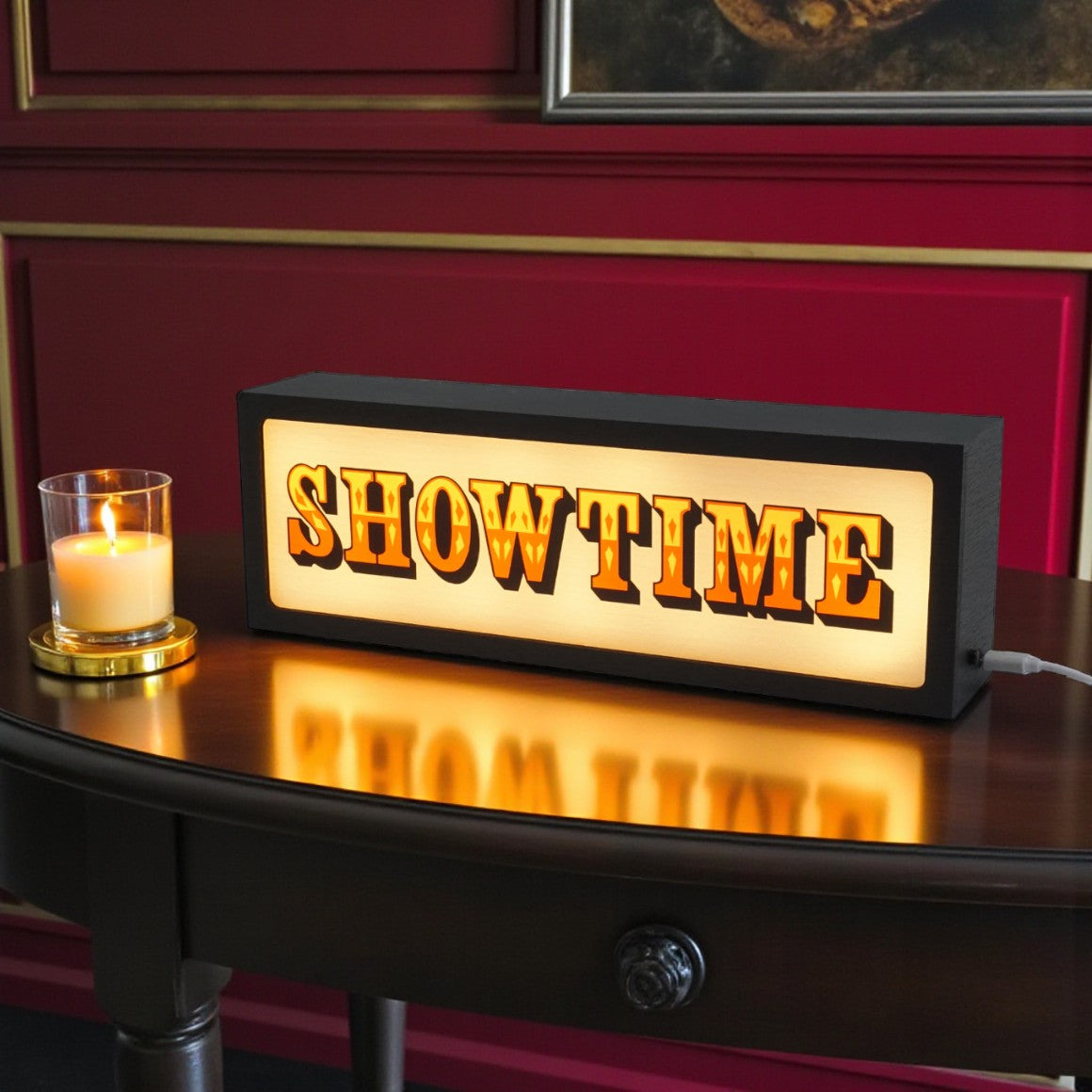 Decorative sign with 'SHOW TIME' text on a wooden surface with a candle in the background.