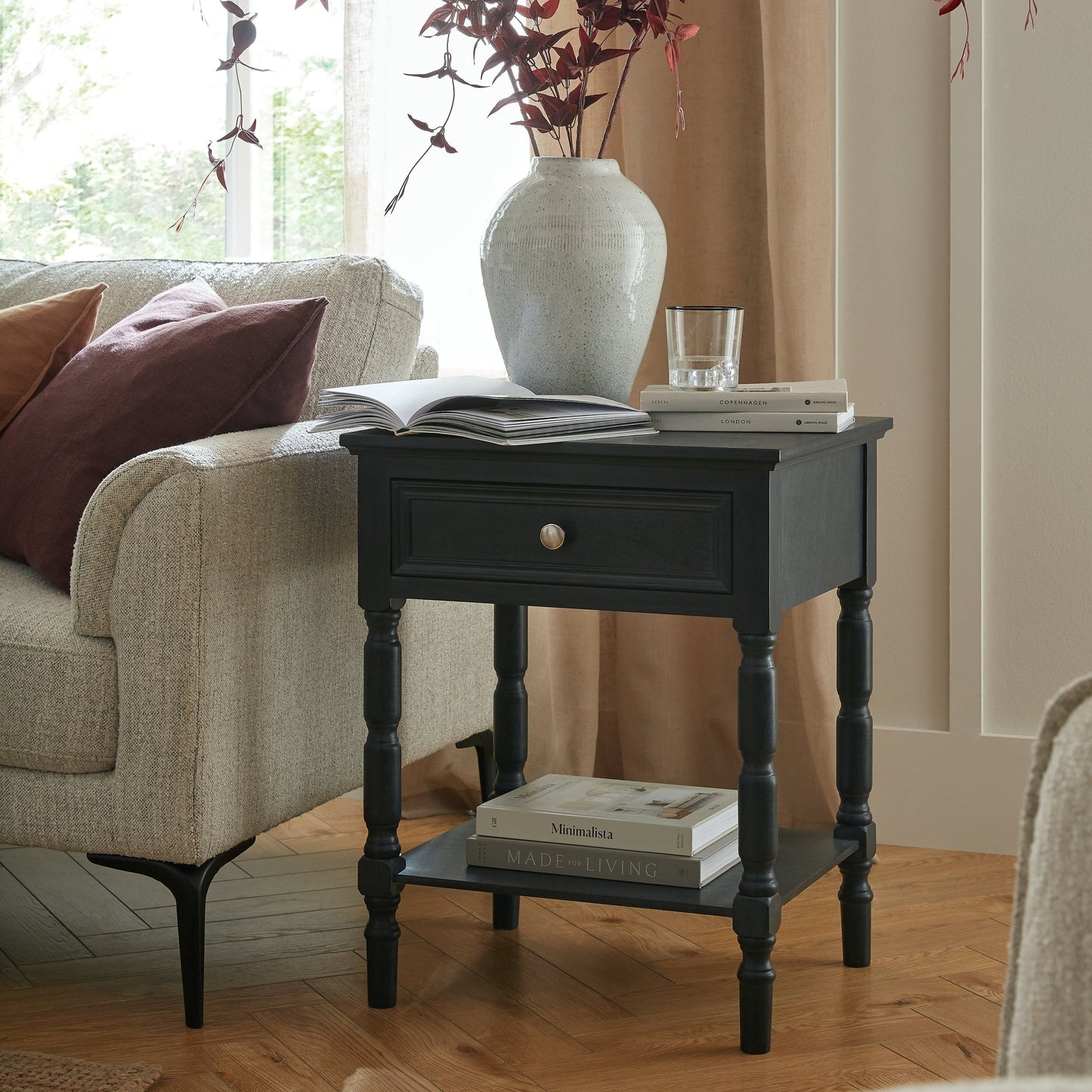 End table with vase and books in a living room setting