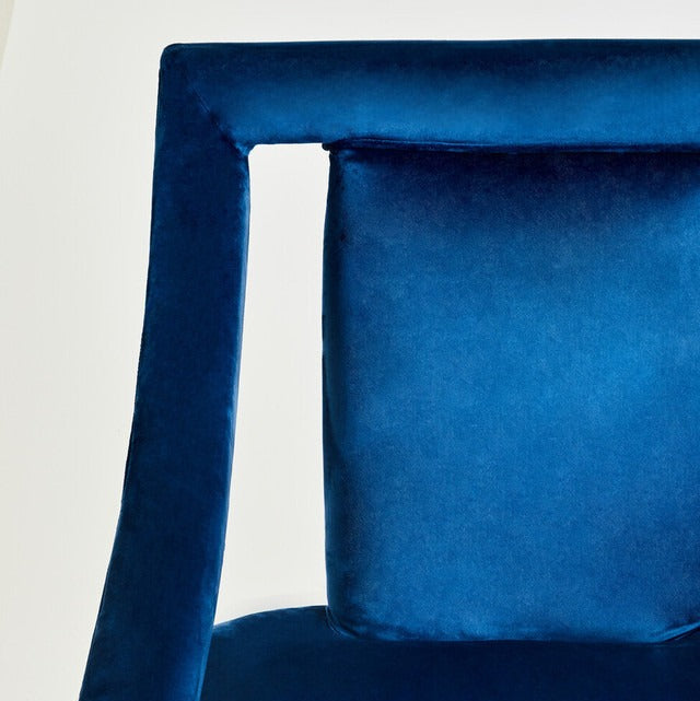 Close-up of a blue velvet chair with a plain background