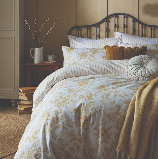 Bedroom with floral bedding and decorative pillows