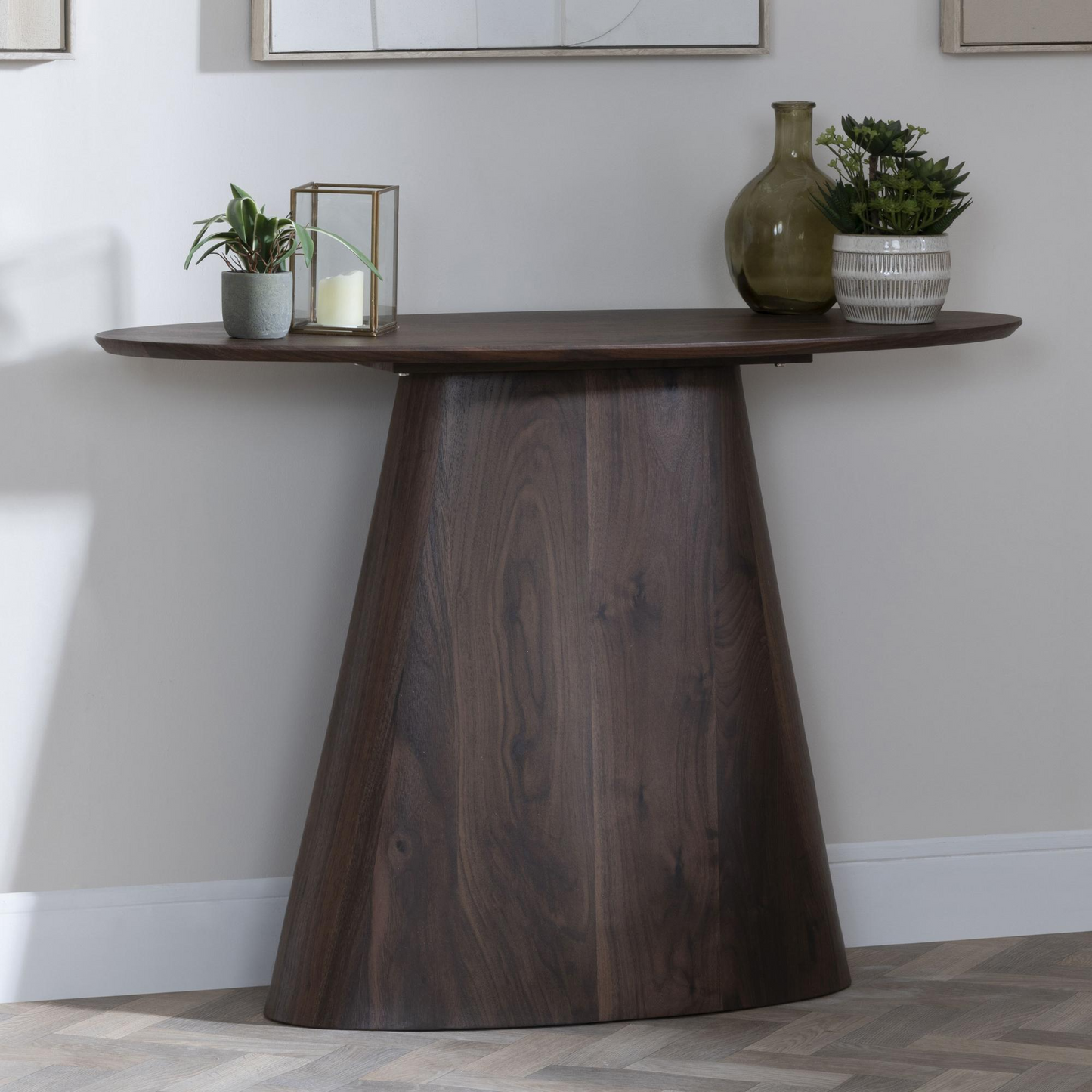 Wooden console table with decorative items against a white wall