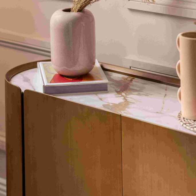 Pink vase with dried plants on a marble surface