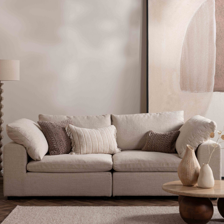 Beige sofa with decorative pillows in a living room setting
